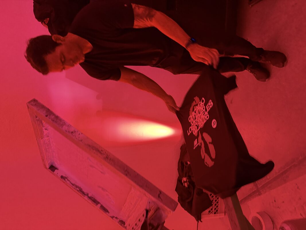 A dense event crowd moving through a venue near a live merch setup